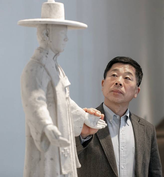 바티칸 성 베드로 대성전에 김대건 신부 조각상을 세운 한진섭 작가가 서울 평창동 가나아트센터 전시장에서 작품을 올려다보고 있다. 바티칸에 설치된 것과 동일한 형태의 60cm 크기 조각상을 새로 만들었다. /박상훈 기자