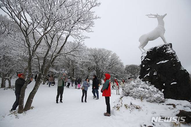 [제주=뉴시스] 우장호 기자 = 주말동안 많은 눈이 내린 가운데 18일 오후 제주 한라산 1100도로 휴게소를 찾은 방문객들이 설경을 감상하며 즐거운 시간을 보내고 있다. 기상청에 따르면 오는 20일부터 이른바 '북극 한파'가 찾아와 올겨울 들어 가장 강력한 추위가 극성을 부릴 것으로 예보됐다. 2023.12.18. woo1223@newsis.com