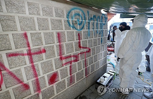 17일 오전 서울 종로구 국립고궁박물관 쪽문 경복궁 담벼락 앞에서 문화재청 관계자들이 전날 누군가가 스프레이로 쓴 낙서 제거 작업을 하고 있다.