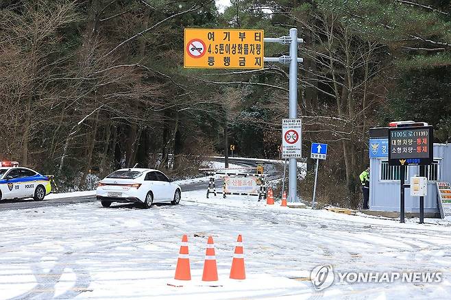 제주 1100도로 차량통제 (제주=연합뉴스) 박지호 기자 = 제주도 산간에 대설특보가 내려진 17일 오전 제주시 어승생 삼거리 1100도로 입구에서 경찰이 차량을 통제하고 있다. 2023.12.17 jihopark@yna.co.kr