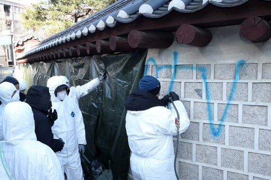 17일 오전 서울 종로구 국립고궁박물관 쪽문 경복궁 담벼락 앞에서 궁능유적본부 관계자들이 전날 누군가가 스프레이로 쓴 낙서 제거 작업을 하고 있다. 연합뉴스