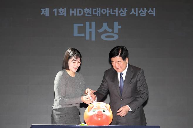 권오갑(오른쪽) HD현대1%나눔재단 이사장이 19일 HD현대 글로벌R&D(연구개발)센터에서 열린 제1회 HD현대아너상 시상식에서 대상을 수상한 ‘얼굴 없는 천사’를 대신해 전주시 노송동 주민센터 김민아 주무관에게 대상 상금을 전달하고 있다. 상금 2억원은 전액 소외계층 지원 사업에 활용될 예정이다. [HD현대 제공]