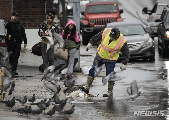 [펜실베니아=AP/뉴시스] 18일(현지시간) 미국 펜실베니아 콜링데일에서 한 근로자가 빗물받이의 쓰레기를 치우고 있다. 2023.12.19.