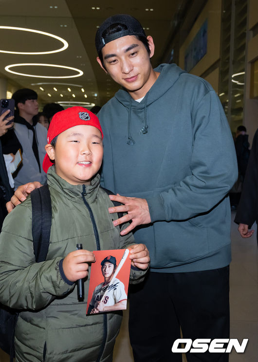 [OSEN=인천공항, 민경훈 기자]메이저리거 이정후가 입국장을 통과한 후 팬에게 사인을 해주고 포즈를 취하고 있다. 2023.12.19 / rumi@osen.co.kr