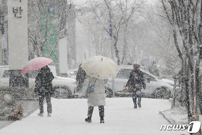 광주와 전남에 많은 눈이 예보된 20일 광주 서구 상무지구에 시민들이 눈을 맞으며 걸어가고 있다.2023.12.20/뉴스1 ⓒ News1 김태성 기자