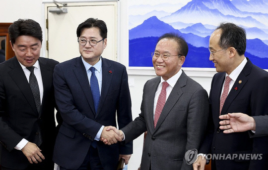 국민의힘 윤재옥 당 대표 권한대행 겸 원내대표와 더불어민주당 홍익표 원내대표가 20일 서울 여의도 국회 운영위원장실에서 2024년도 예산안 합의를 마친 뒤 악수하고 있다. 연합뉴스