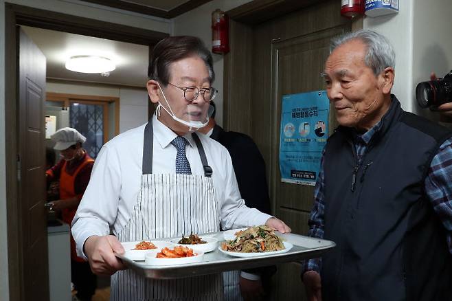 이재명 더불어민주당 대표가 21일 오전 서울 영등포구 구립 큰숲 경로당에서 어르신들의 점심 식사 자리에 반찬을 놓고 있다. 이 대표는 어르신들과의 식사 자리를 마친 후 주5일 점심 제공 정책 간담회에 참석했다.(사진=연합뉴스)