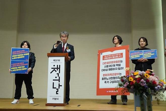 ▲전국언론노동조합 출판노조협의회가 10월11일 서울 서대문구 연세대 동문회관에서 열린 '제37회 책의날 기념식'에서 윤철호 대한출판문화협회 회장을 향해 단체교섭을 요구하는 기습시위를 벌이고 있다. 사진=언론노조 제공
