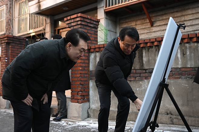 윤석열 대통령이 21일 서울 중랑구 소규모 주택정비 관리지역인 모아타운 사업지를 찾아 오세훈 서울시장으로부터 도심 주택공급 현장 설명을 듣고 있다.   대통령실 제공