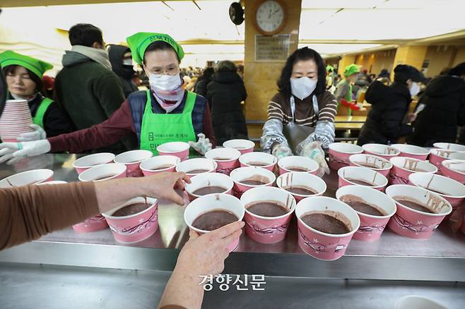 밤이 가장 길고 낮이 가장 짧아진다는 절기상 동지인 22일 서울 종로구 조계사에서 열린 팥죽 공양 행사에서 봉사자들이 팥죽을 나눠주고 있다.  성동훈 기자