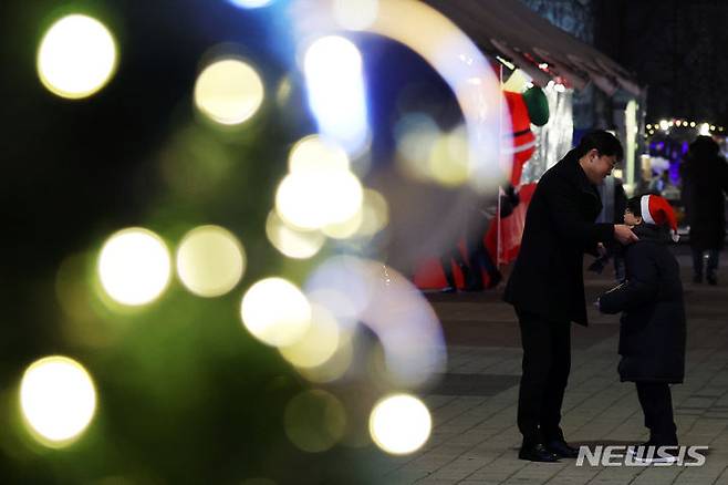 [서울=뉴시스] 최진석 기자 = 22일 서울 광진구 뚝섬한강공원에 열린 2023 로맨틱 한강 크리스마스 마켓을 찾은 아버지가 아들에게 목도리를 둘러주 있다. 2023.12.22. myjs@newsis.com