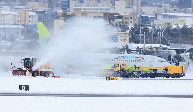 폭설이 내린 22일 오후 제주국제공항 활주로에서 제설차량이 눈을 치우고 있다./연합뉴스