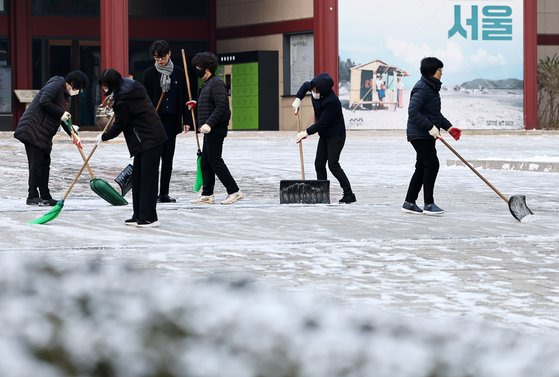 지난 20일 오전 서울역사박물관 앞에서 관계자들이 제설작업을 하고 있다. 연합뉴스