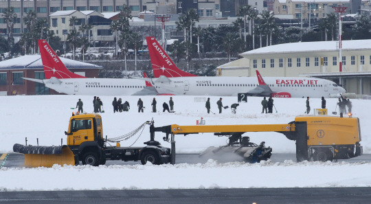 ‘제주공항 제설 대작전’ 대설특보가 내려진 지난 22일 오후 폭설로 인해 운항이 전면 중단된 제주국제공항 활주로에서 군인 장병들과 제설차가 쌓인 눈을 치우고 있다. 뉴시스