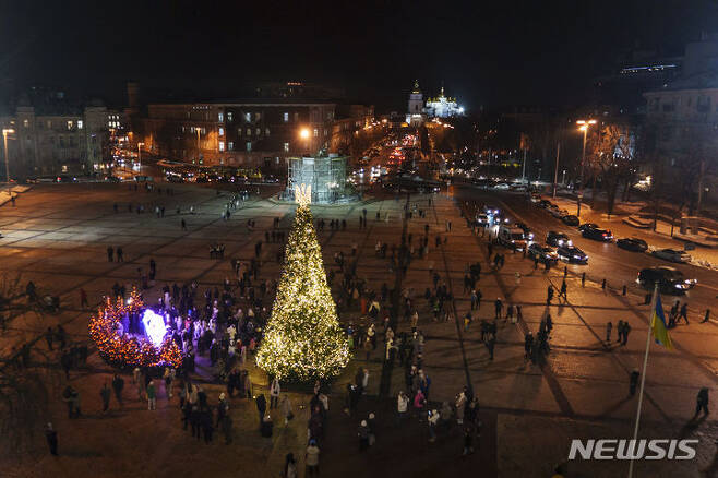 [키이우=AP/뉴시스] 우크라이나가 106년 만에 오는 25일 성탄절을 기념한다. 우크라이나는 이 같은 변화를 통해 전쟁 3년 차를 목전에 두고 러시아 문화를 지우려는 생각이다. 사진은 지난 6일(현지시간) 우크라이나 수도 키이우의 성소피아 광장에서 시민이 새로 설치된 성탄절 트리 주변에 모여 구경하는 모습. 2023.12.23.