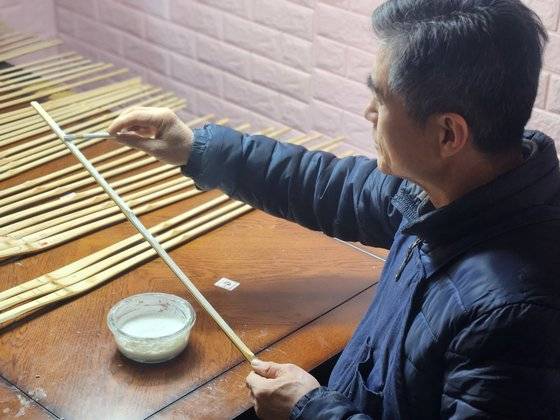 지난 20일 신용만 사범이 대구 수성구 자신의 작업실에서 죽도 안쪽 면에 자신이 개발한 고무코팅재 '다솜유'를 도포하고 있다. 김정석 기자
