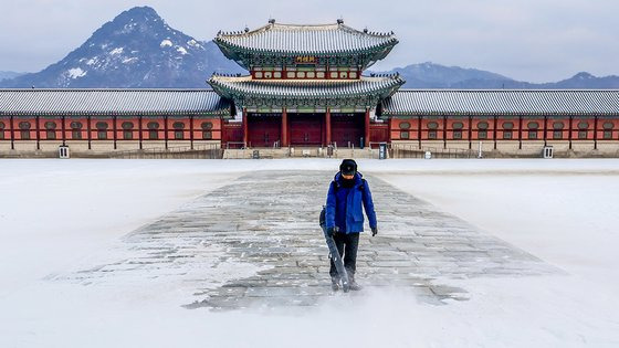 크리스마스 이브인 24일 서울 종로구 경복궁에서 관계자가 밤에 내린 눈을 치우고 있다. 뉴시스