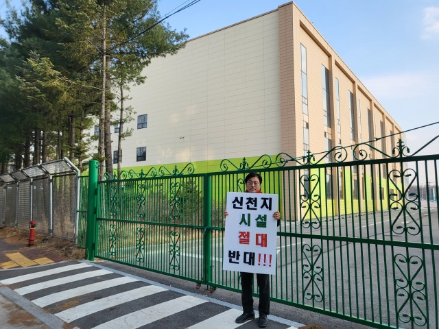 김종혁 국민의힘 고양병 당협위원장이 24일 신천지 교회 조성이 계획된 고양시 일산동구 풍동 물류센터 건물 앞에서 신천지 시설을 반대하는 팻말을 들고 있다. 국민의힘 고양병 당협위원회 제공