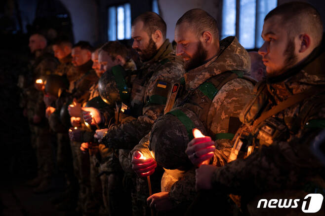 우크라이나 육군 제14기계화여단 소속 장병들이 동부 최전방 쿠피안스크에서 성탄절을 하루 앞둔 24일(현지시간) 촛불을 든 채 예배를 진행하고 있다. 2023.12.24. ⓒ 로이터=뉴스1 ⓒ News1 김성식 기자