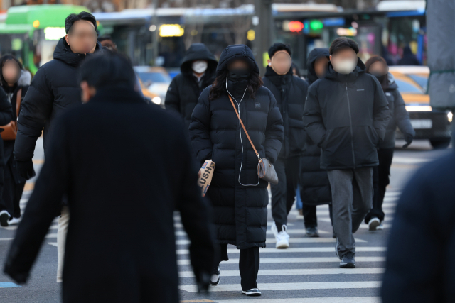 22일 오전 서울 광화문네거리에서 두꺼운 옷을 입은 시민들이 횡단보도를 건너고 있다. 연합뉴스
