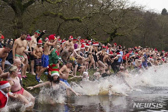 [버밍엄=AP/뉴시스] 성탄절인 25일(현지시각) 영국 버밍엄 서튼 파크의 블랙루트 풀에서 크리스마스 수영 대회가 열려 참가자들이 물에 뛰어들고 있다. 2023.12.26.