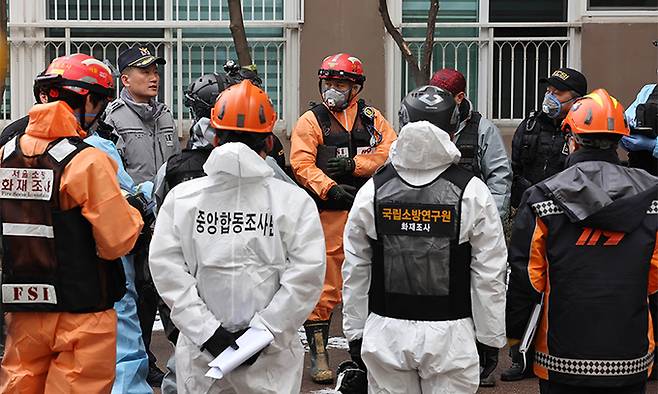 26일 서울 도봉구 한 아파트 화재현장에서 경찰과 소방 등 관계당국으로 구성된 합동감식팀이 감식을 하기에 앞서 회의를 하고 있다. 전날 이 아파트에선 화재가 발생해 32명의 사상자가 발생했다. 남정탁 기자