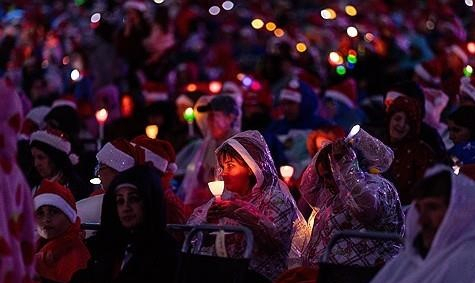 지난 24일 호주 멜버른에서 열린 캐럴 공연 행사에서 참가자들이 우비를 쓴 채 공연을 보고 있다. 사진=EPA·연합뉴스