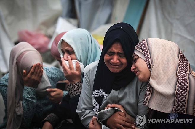 이스라엘 공습으로 가족 잃은 가자지구 주민들 (데이르 알발라 AFP=연합뉴스) 이스라엘군의 밤샘 공습으로 가족을 잃은 가자지구 알마가지 난민 캠프 주민들이 25일(현지시간) 데이르 알발라 알아크사 병원에서 열린 대규모 장례식에서 애도하고 있다. 팔레스타인 무장 정파 하마스가 통치하는 가자지구 보건부에 따르면 이스라엘군의 전날 공격으로 알마가지 주민 최소 70명이 숨졌다. 2023.12.26 besthope@yna.co.kr