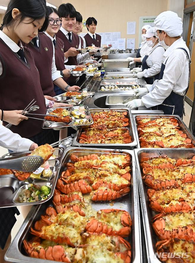 [수원=뉴시스] 김종택기자 = 14일 경기도 수원시 효원고등학교에서 학생들이 점심시간에 랍스터를 배식하고 있다. 탄소중립시범학교로 운영 중인 효원고는 학교 급식 음식물 쓰레기 줄이기 활동 결과 전년대비 처리비용 49.2% 절감, 쓰레기발생량 55% 감소에 적극 참여한 학생과 교직원들을 격려하기 위해 랍스터 테일 구이를 점심 식단으로 제공했다. 2023.11.14. jtk@newsis.com