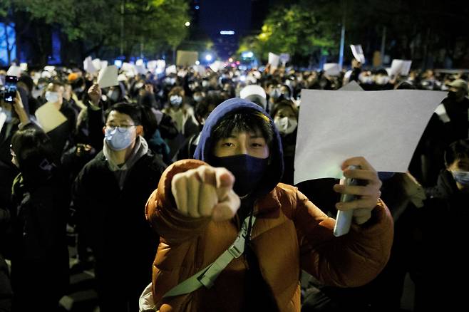 ‘공산당 검열에 저항’ 백지 시위 - 27일 밤 중국 베이징에서 제로 코로나 정책에 반대하고 신장 우루무치 화재 참사 희생자를 추모하는 시위대가 백지를 들고 항의하고 있다. 시민들이 든 백지는 공산당의 검열과 통제에 저항한다는 의미로, 2020년 홍콩에서 국가보안법에 반대하는 시위를 벌일 때도 등장했다. /로이터 뉴스1