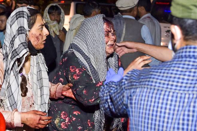 26일 카불 공항 밖에서 두 차례의 폭발로  부상당한 여성들이 병원에 도착하고 있다./AFP 연합뉴스