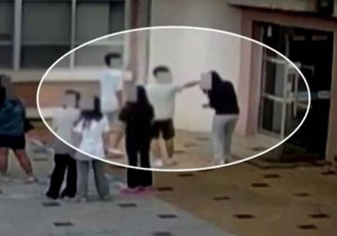 천안의 한 초등학교에서 가해 학생들이 또래 여학생을 둘러싼 채 머리카락을 잡는 등 집단으로 폭행하는 모습. YTN 보도화면 갈무리