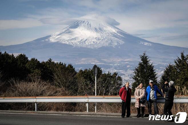 일본 시즈오카현(県) 한 도로에서 관광객들이 후지산을 배경으로 사진을 찍고 있다. ⓒ AFP=뉴스1 ⓒ News1 권진영 기자