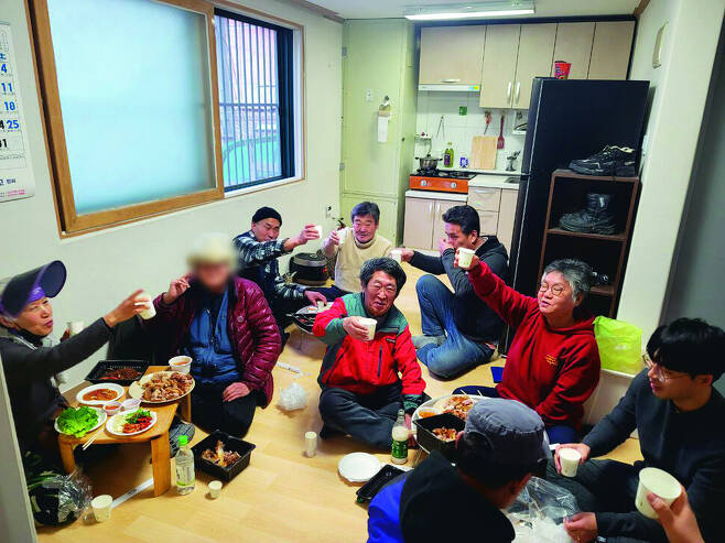 지난 3월 홈리스야학 학생·교사와 활동가들이 서울 종로구 혜화동에 있는 유철용(왼쪽 둘째)씨의 매입임대주택에서 축하 집들이를 하고 있다. 지난해 9월 이사 간 이 임대주택은 그의 평생에 ‘집이라고 할 수 있는 첫 집’이었다. 홈리스행동 제공