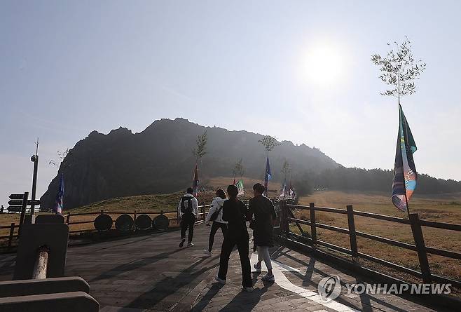 "해돋이 명소 성산일출봉으로 가자" (서귀포=연합뉴스) 변지철 기자 = 갑진년 '청룡의 해' 2024년을 앞둔 30일 제주의 해돋이 명소인 성산일출봉에서 제31회 성산일출축제가 개막, 관광객과 도민들이 성산일출봉에 오르고 있다. 2023.12.30 bjc@yna.co.kr