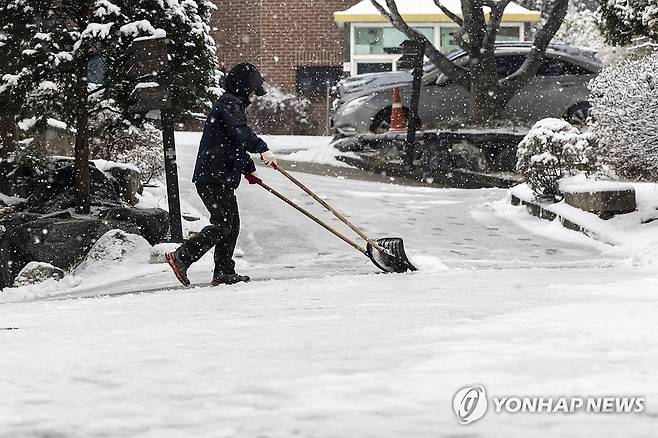 서울 전역 대설주의보 (서울=연합뉴스) 윤동진 기자 = 대설주의보가 내려진 30일 오전 서울 중구에서 한 시민이 제설 작업을 하고 있다. 2023.12.30 mon@yna.co.kr