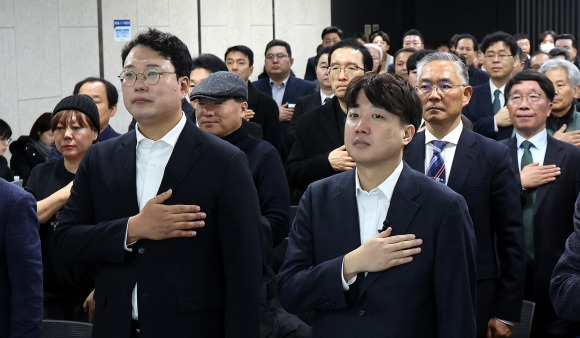 이준석(오른쪽) 전 국민의힘 대표와 천하람 개혁신당 창당준비위원장이 1일 오전 서울 용산구 서울역 대회의실에서 열린 개혁신당 신년 하례회에서 참석자들과 국민의례를 하고 있다. 2024.1.1 뉴스1