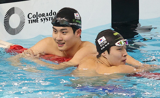 Swimmers Hwang Sun-woo, left, and Kim Woo-min check their records after finishing a 200-meter race at the national squad selection contest at Gimcheon Swimming Pool in Gimcheon, North Gyeonsang on Monday. [YONHAP]