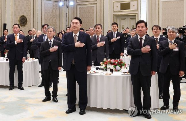 윤석열 대통령이 3일 청와대 영빈관에서 열린 '2024년 신년 인사회'에서 김진표 국회의장, 이종석 헌법재판소장, 조희대 대법원장, 최태원 대한상공회의소장 등과 함께 국기에 경례하고 있다. [사진출처=연합뉴스]