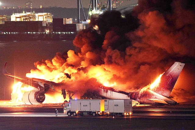 2일 오후 도쿄 하네다공항 활주로에서 일본항공 여객기가 해상보안청 항공기와 충돌한 후 발생한 화재로 화염이 치솟고 있다. AFP연합뉴스
