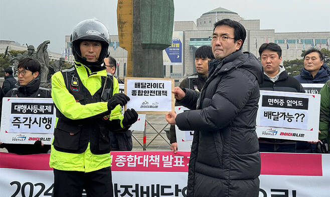 3일 서울 용산구 대통령실 앞에서 열린 기자회견에서 구교현 라이더유니온지부장이 ‘배달라이더 종합안전대책안’을 경찰에게 제출하고 있다. 경찰은 해당 의견서를 대통령실에 제출할 예정이라고 밝혔다. 윤준호 기자