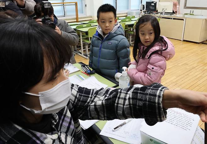 4일 오후 서울 서초구 원명초등학교에서 열린 신입생 예비소집에서 쌍둥이 예비 초등학생들이 입학 안내를 받고 있다. 백소아 기자