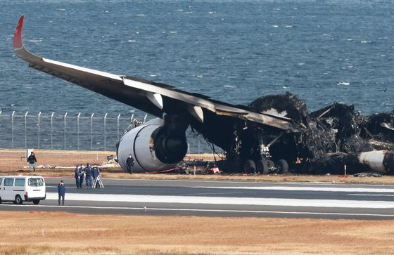 4일 하네다 공항 활주로 옆에 일본 해상보안청 항공기와 충돌한 JAL 여객기의 잔해를 조사관들이 조사하고 있다. EPA·지지=연합뉴스