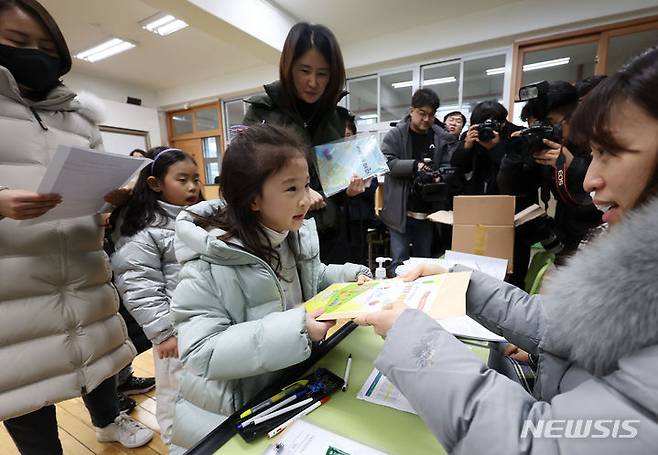 [서울=뉴시스] 홍효식 기자 = 2024학년도 초등학교 신입생 예비소집일인 4일 서울 서초구 원명초등학교에서 입학을 앞둔 어린이가 입학 안내자료를 받고 있다. 2024.01.04. yesphoto@newsis.com