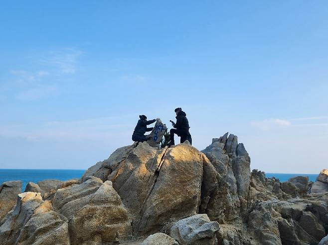 울산 동구청 공무원들이 낙서로 훼손된 암석을 정비하고 있다. 동구청 제공