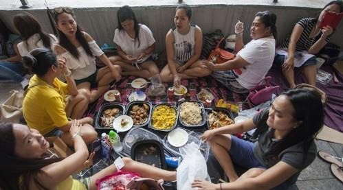 홍콩의 외국인 입주 가사도우미들이 휴일을 맞아 야외에서 한 데 모여 휴식을 취하는 모습 [EPA]