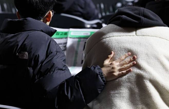 지난달 14일 오후 서울 송파구 잠실학생체육관에서 열린 진학사 정시 합격전략 설명회를 찾은 한 수험생이 친구의 등을 두드리고 있다 [사진 제공=연합뉴스]