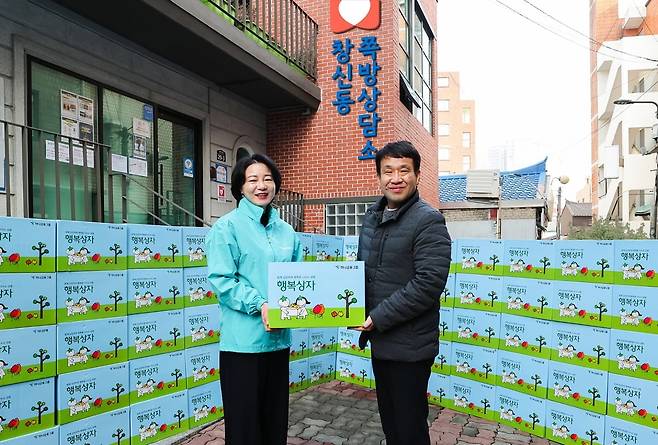 김덕순 하나은행 북부영업본부 지역대표(사진 왼쪽)가 이도희 서울시립 창신동쪽방상담소 소장(오른쪽)에게 행복상자를 전달하고 있다. 하나금융 제공.