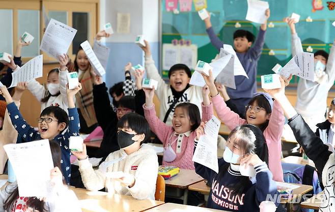 [대구=뉴시스] 이무열 기자 = 22일 대구 수성구 대구 동성초등학교 3학년 교실에서 학생들이 겨울방학 안내문을 흔들며 즐거워하고 있다. 2023.12.22. lmy@newsis.com