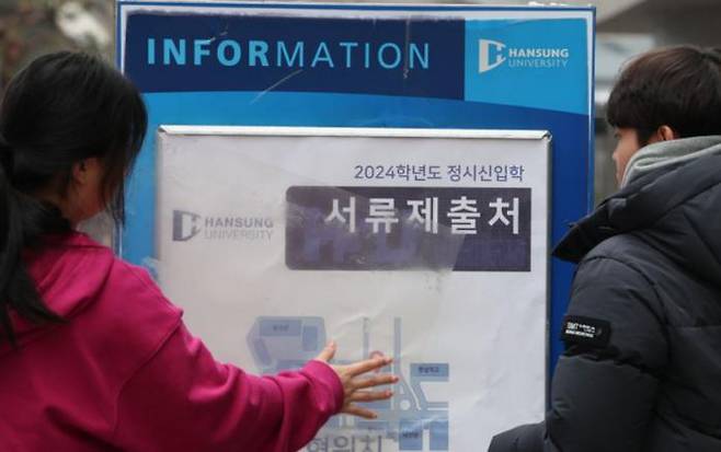 Students post a notice of the application center at Hansung University in Seongbuk-gu, Seoul, on March 3, as the application process for the 2024 university entrance examination begins. Yonhap News Agency